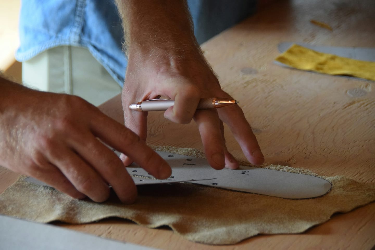 Material detail: leather being cut on a workbench